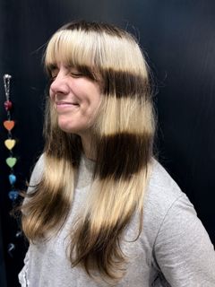 Client with raccoon tail color, long layers, and bangs